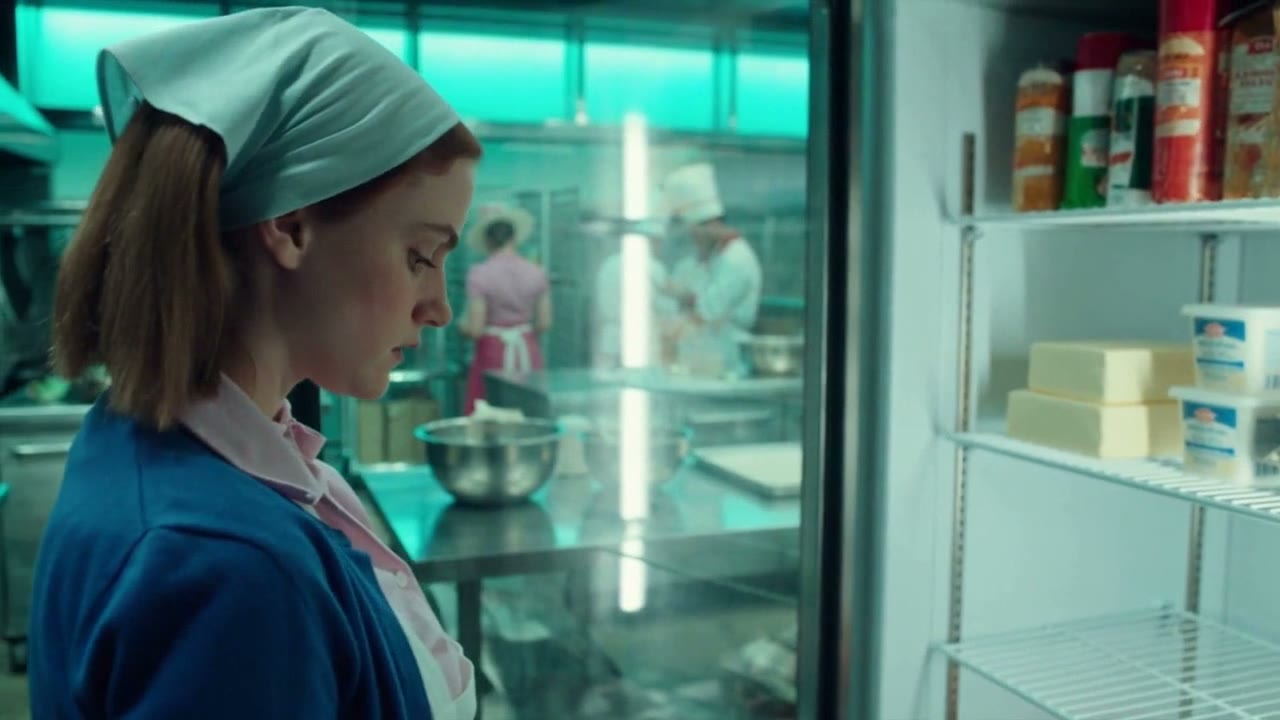 A baker putting stock away in the dairy fridge