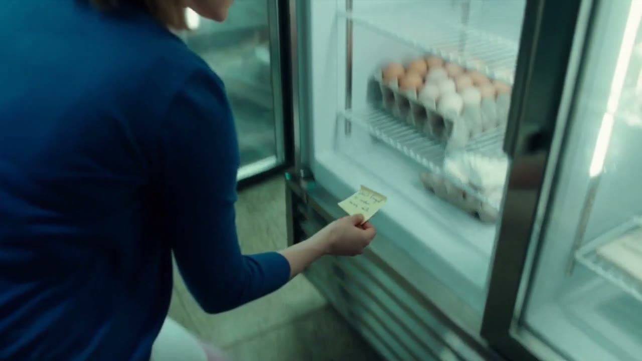 A baker holding a handwritten note at the fridge door